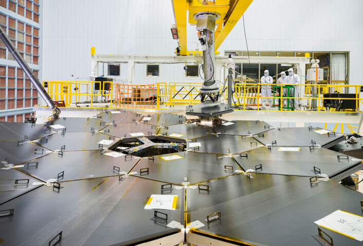 En robotarm ble brukt til å sette på plass det siste av de 18 speilsegmentene i romteleskopet James Webb. Dette skjedde den 4. februar i det store renrommet til Goddard Space Flight Center i Greenbelt, Maryland i USA. (Foto: NASA/Chris Grunn) En robotarm ble brukt til å sette på plass det siste av de 18 speilsegmentene i romteleskopet James Webb. Dette skjedde den 4. februar i det store renrommet til Goddard Space Flight Center i Greenbelt, Maryland i USA. (Foto: NASA/Chris Grunn)