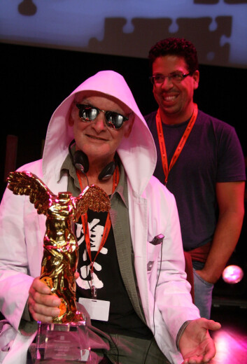 Tross sine fantasifulle påfunn er Joe Davis anerkjent. Han er tilknyttet MIT i Boston både som kunstner og forsker innen molekylærbiologi og bioinformatikk. Her mottar han Prix Ars Electronica for sitt verk Bacterial Radio i Østerrike i 2012. (Foto: Manfred Werner, Creative Commons Attribution-Share Alike 3.0 Unported licence.) Tross sine fantasifulle påfunn er Joe Davis anerkjent. Han er tilknyttet MIT i Boston både som kunstner og forsker innen molekylærbiologi og bioinformatikk. Her mottar han Prix Ars Electronica for sitt verk Bacterial Radio i Østerrike i 2012. (Foto: Manfred Werner, Creative Commons Attribution-Share Alike 3.0 Unported licence.)