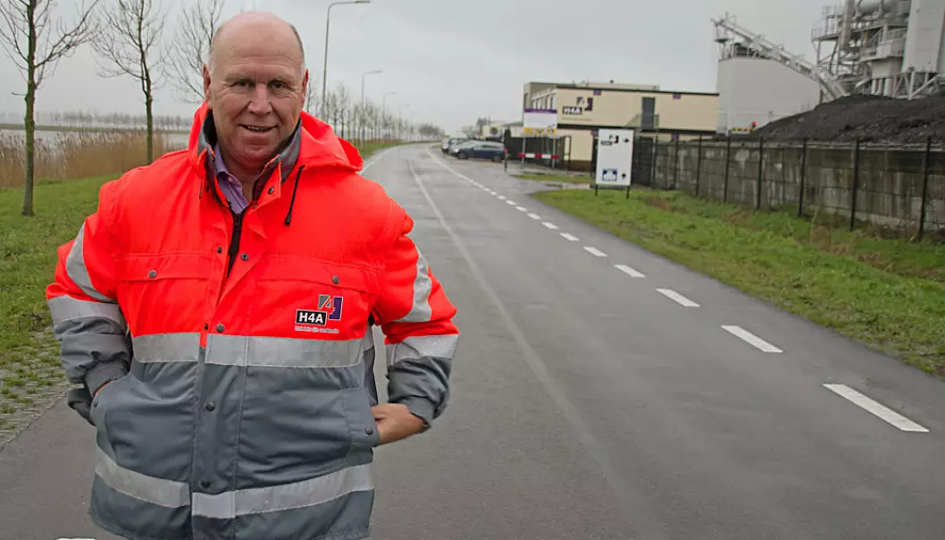Den er verdens første – Ronald Verbruggen står på bioasfalten, som logisk nok ligger på veien rett forbi asfaltfabrikken. (Foto: Georg Mathisen)