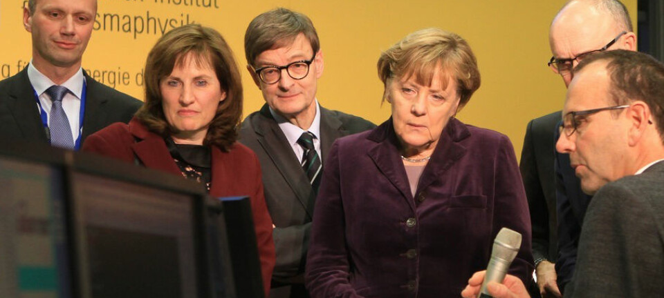 Merkel og forskerne kikker spent etter resultatet, etter at forbundskansleren trykte på knappen.  (Foto: IPP, Norbert Fellechner)