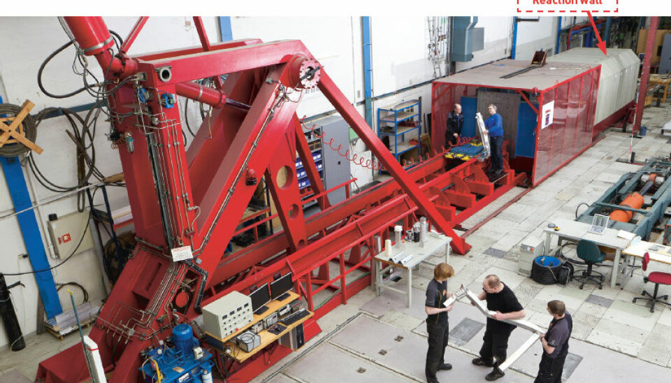 The two-storey bright red “Kicking Machine” is so powerful it needs a 150,000 tonne reaction wall behind it to absorb the force of its blow. (Photo. SIMLab)