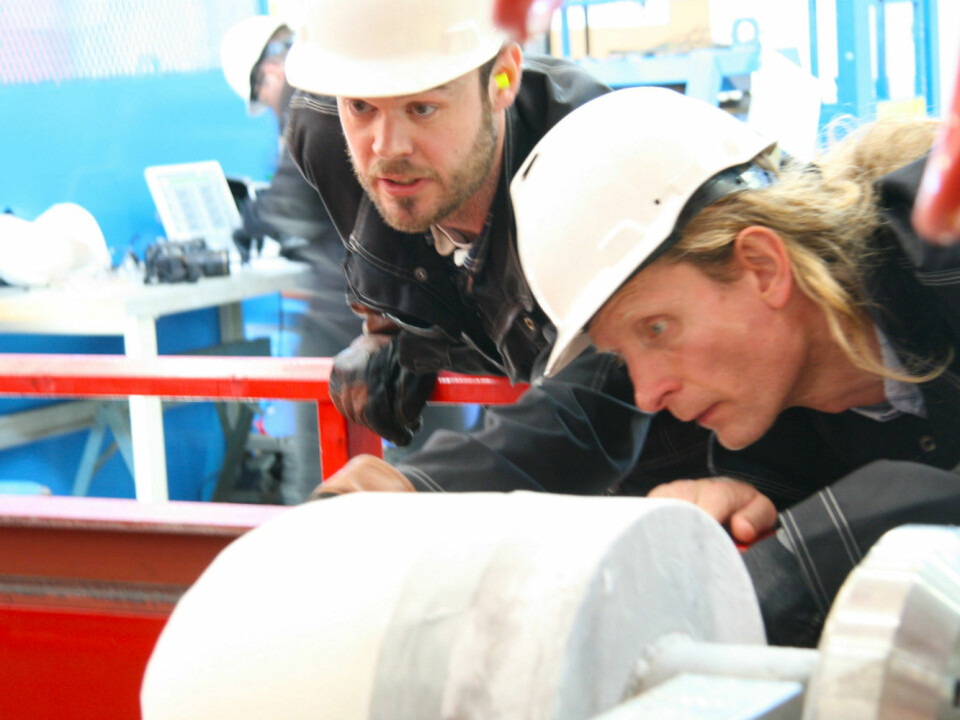 Knut Høyland (right), a SAMCoT professor, inspects the ice bullet with PhD candidate Torodd Nord. (Photo: Nancy Bazilchuk)