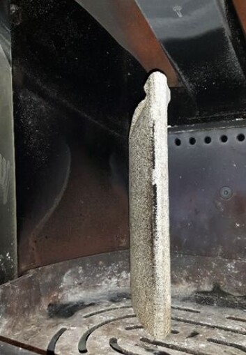 Brennplatene i ovnen er løse og kan trekkes fram som dette. Det kan ofte legge seg mye sot på baksiden, noe som gjør at ovnen får lavere effekt. (Foto: Sintef) Brennplatene i ovnen er løse og kan trekkes fram som dette. Det kan ofte legge seg mye sot på baksiden, noe som gjør at ovnen får lavere effekt. (Foto: Sintef)