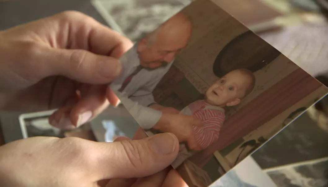 Solveig holder et bilde av henne og morfaren fra da hun var baby. (Foto: Ole André Rekkedal, NRK)