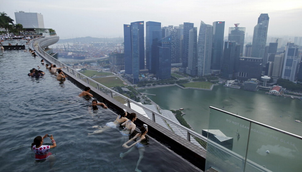 Turister bader i bassenget på taket av hotellet Marina Bay Sands i Singapore. (Foto: Edgar Su, Reuters, NTB Scanpix)