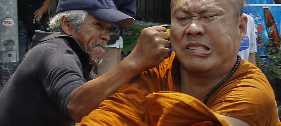 Vold og slåssing er et menneskelig fenomen. Her går en demonstrant i Bangkok løs på en munk som klagde på demonstrasjonen. (Foto: Chaiwat Subprasom/Reuters)