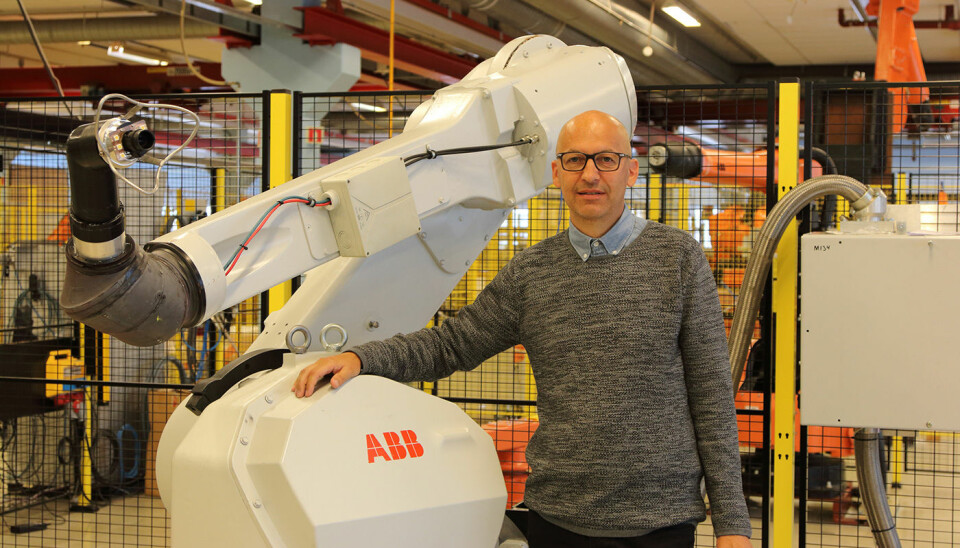 Morten Mossige in front of a ABB robot. Morten Mossige's Industrial PhD at the University of Stavanger is the first of its kind at ABB in Norway. (Photo: Leiv Gunnar Lie, UiS)