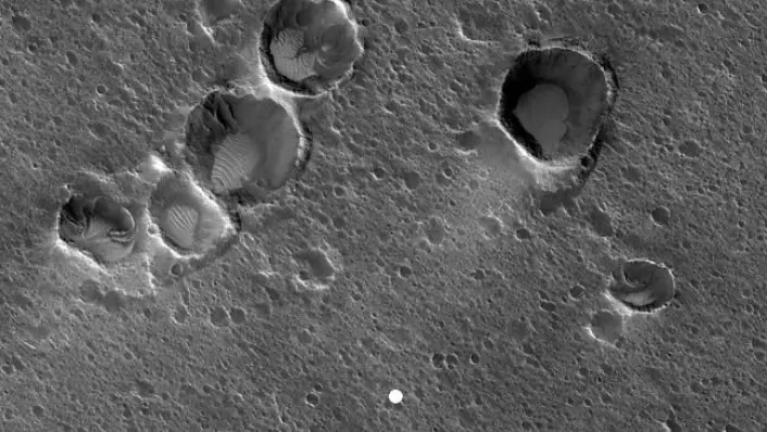 Acidalia Planitia sett frå NASAs Mars Reconnaissance Orbiter. Den kvite prikken representerer storleiken og plasseringa av den hypotetiske Mars-basen Ares 3. (Foto: Hirise, Mars Reconnaissance Orbiter, NASA)