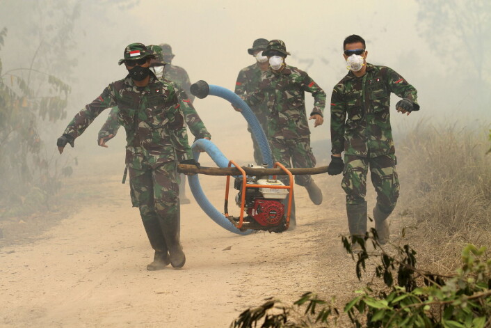 Indonesiske soldater bærer en vannpumpe i de brannherjede skogene på Sumarta i Indonesia. (Foto: Antara foto, Reuters) Indonesiske soldater bærer en vannpumpe i de brannherjede skogene på Sumarta i Indonesia. (Foto: Antara foto, Reuters)