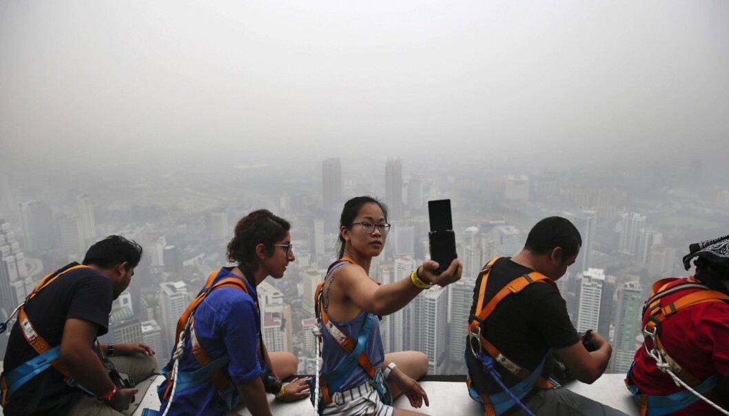 En kvinnelig turist tar en selfie på toppen av et høyt bygg i Kuala Lumpur i Malaysia i begynnelsen av oktober. Skogbranntåke ligger tykt over Kuala Lumpur, Singapore og andre steder i området. (Foto: Fazry Ismail/Epa) En kvinnelig turist tar en selfie på toppen av et høyt bygg i Kuala Lumpur i Malaysia i begynnelsen av oktober. Skogbranntåke ligger tykt over Kuala Lumpur, Singapore og andre steder i området. (Foto: Fazry Ismail/Epa)