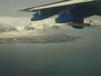 Part of Isfjorden and Erdmannflya west of Longyearbyen, as seen from the FAAM research aircraft BAe 146. Also visible on the wing is the measuring equipment used to collect air samples. (Photo: Ignacio Pisso/NILU)