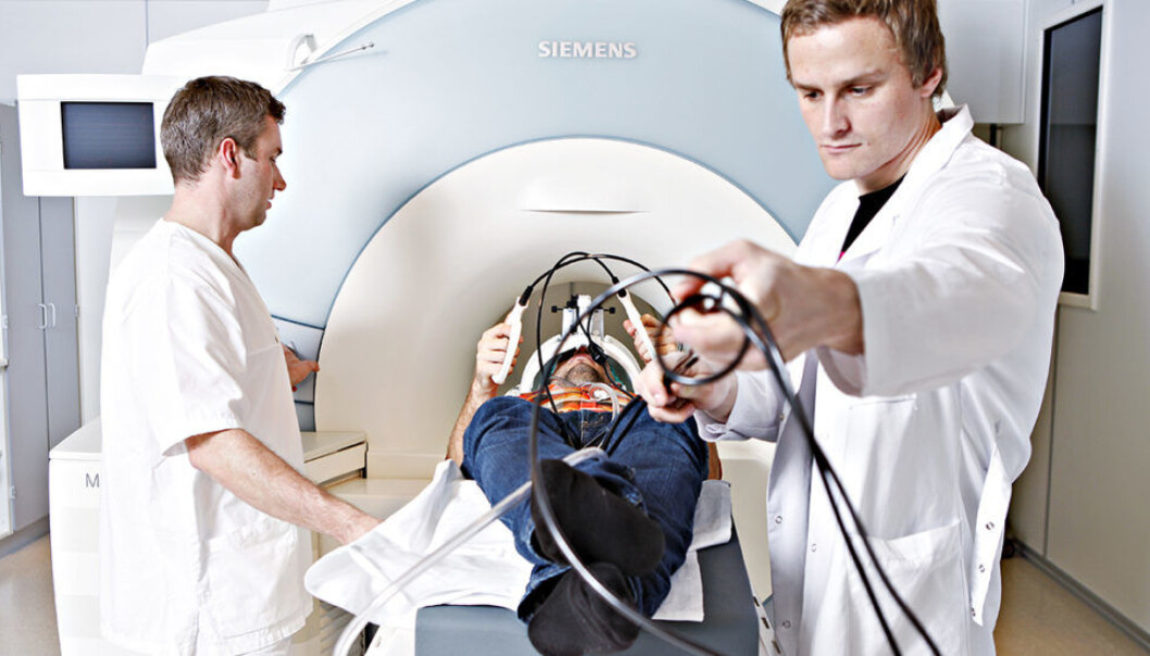 Chief Radiographer Bjarte Snekvik and Associate Professor Alexander Olsen illustrate how their study subjects perform the fMRI task (the person in the photo was not a study participant). Study participants used specially designed response buttons (as shown) and could view the task through video goggles. (Photo: Geir Mogen, NTNU) Chief Radiographer Bjarte Snekvik and Associate Professor Alexander Olsen illustrate how their study subjects perform the fMRI task (the person in the photo was not a study participant). Study participants used specially designed response buttons (as shown) and could view the task through video goggles. (Photo: Geir Mogen, NTNU)