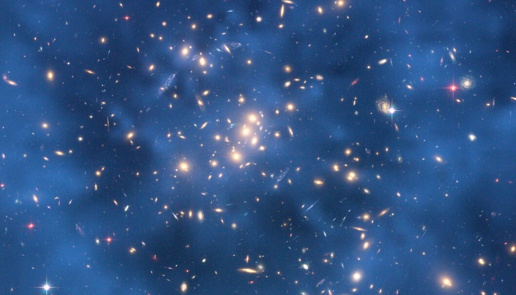 Mørk materie er usynlig, men kan registreres gjennom såkalt gravitasjonslinsing. Her ser vi den mørke materien som en blå ring rundt galaksen CL0024+17. (Foto: Jee og Ford mfl, NASA/ESA) Mørk materie er usynlig, men kan registreres gjennom såkalt gravitasjonslinsing. Her ser vi den mørke materien som en blå ring rundt galaksen CL0024+17. (Foto: Jee og Ford mfl, NASA/ESA)