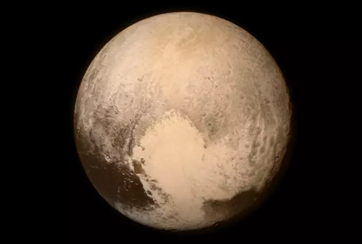 Dette bildet av Pluto ble tatt 13. juli 2015 klokka 22 norsk tid, 16 timer før romsonden New Horizons passerte nærmest dvergkloden i en avstand på 12 500 kilometer. Her er avstanden hele 768 000 kilometer, rundt dobbelt så stor som avstanden mellom jorda og månen. Bildet er opprinnelig tatt i svart-hvitt med kameraet  Long Range Reconnaissance Imager (LORRI), men er tilført fargeinformasjon med lavere oppløsning fra kameraet Ralph. Bildet domineres av et stort, lyst området som kalles "hjertet". Det måler rundt 1600 kilometer tvers over. På hver side ligger mørkere terreng ved Plutos ekvator. Mye av "hjertet" framstår som jevnt. Det kan tyde på at det er et ungt terreng hvor geologiske prosesser fortsatt pågår, siden det ennå ikke har fått arr av meteorittnedslag. (Foto:  NASA/APL/SwRI)
