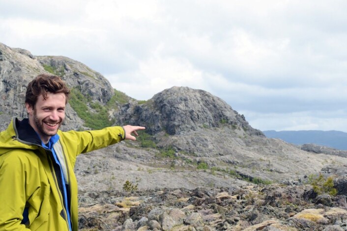 Forsker Fredrik Høgaas peker ut strandlinja i fjellet i bakgrunnen. Frost og sjøis har arbeidet hardt for å lage linja. (Foto: Gudmund Løvø) Forsker Fredrik Høgaas peker ut strandlinja i fjellet i bakgrunnen. Frost og sjøis har arbeidet hardt for å lage linja. (Foto: Gudmund Løvø)