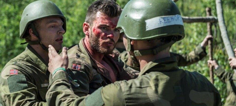 To aspiranter prøver å håndtere en 'skadd' soldat' under opptak til Forsvarets lederutdanning.  (Foto: Forsvaret)