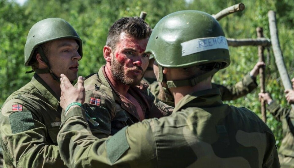 To aspiranter prøver å håndtere en 'skadd' soldat' under opptak til Forsvarets lederutdanning.  (Foto: Forsvaret)