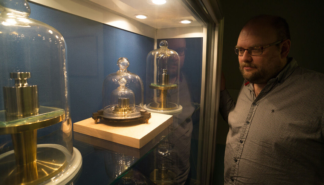 Harald Hauglin betrakter den norske standardkiloen i midten på bildet. Kiloloddet er den siste fysiske enkeltgjenstanden som definerer en måleenhet. Utviklingen går mot å bruke fysiske naturkonstanter, som for eksempel lyshastigheten og energinivåer i atomer. (Foto: Arnfinn Christensen, forskning.no) Harald Hauglin betrakter den norske standardkiloen i midten på bildet. Kiloloddet er den siste fysiske enkeltgjenstanden som definerer en måleenhet. Utviklingen går mot å bruke fysiske naturkonstanter, som for eksempel lyshastigheten og energinivåer i atomer. (Foto: Arnfinn Christensen, forskning.no)