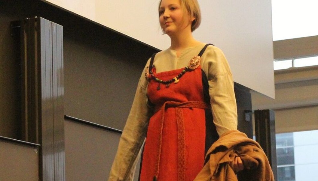 En komplett kvinnedrakt i en av vikingtidens mest populære farger, nemlig rød. Skålspenner holder kjolen oppe. Denne typen spenner gikk av moten midtveis i vikingtiden. (Foto: Johan Skov Andersen) En komplett kvinnedrakt i en av vikingtidens mest populære farger, nemlig rød. Skålspenner holder kjolen oppe. Denne typen spenner gikk av moten midtveis i vikingtiden. (Foto: Johan Skov Andersen)