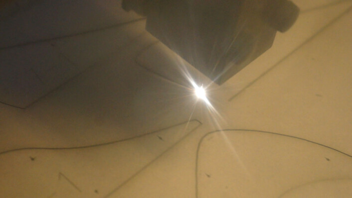 Laserkutteren skjærer ut profiler i papp ut fra digitale 3D-modeller. Profilene limes sammen for hånd til store pappmodeller, av samme type som landskapsarkitekter lenge har brukt. (Foto: Fra video av Arnfinn Christensen) Laserkutteren skjærer ut profiler i papp ut fra digitale 3D-modeller. Profilene limes sammen for hånd til store pappmodeller, av samme type som landskapsarkitekter lenge har brukt. (Foto: Fra video av Arnfinn Christensen)