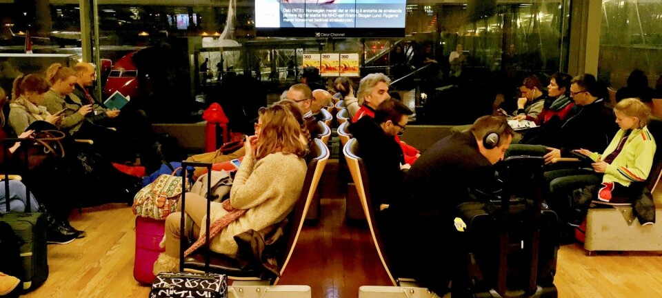 Streikerammede passasjerer venter på Gardermoen under streiken i mars. På skjermen bak et bilde av Norwegian-sjef Bjørn Kjos. (Foto: Håkon Mosvold Larsen, NTB scanpix)