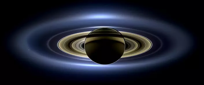 Saturn sett fra Cassini-sonden. Solen er bak Saturn, og gir planeten et dramatisk skjær. E-ringen, som blant annet består av partikler fra Enceladus, er den ytterste ringen vi kan se på dette bildet. (Foto: NASA)