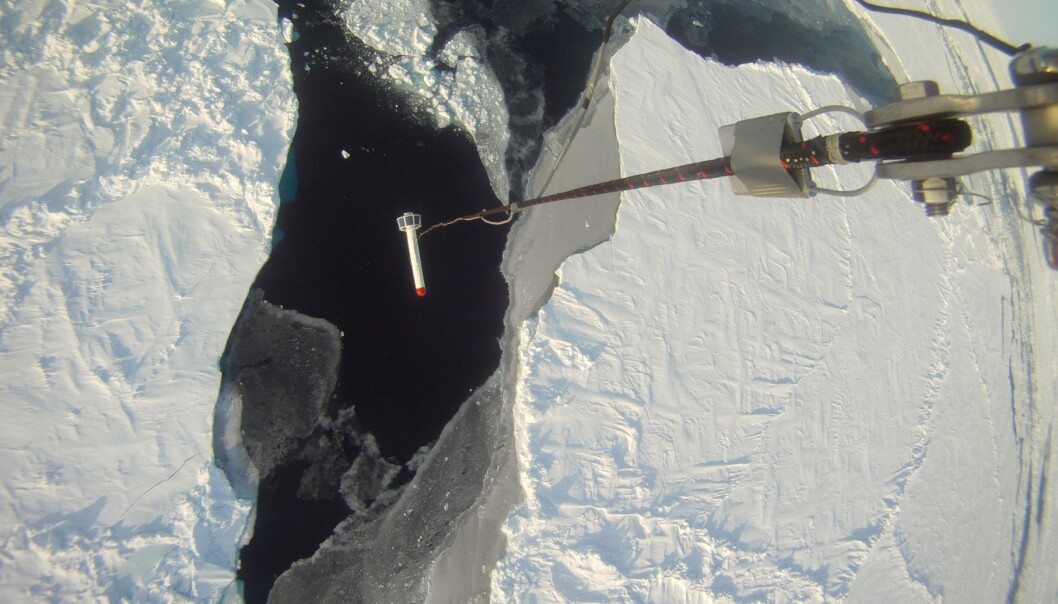 Tykkelsen på isen blir målt av et instrument som henger under helikopteret mens det flyr i lav høyde. (Foto: Sebastian Gerland, Norsk Polarinstitutt) Tykkelsen på isen blir målt av et instrument som henger under helikopteret mens det flyr i lav høyde. (Foto: Sebastian Gerland, Norsk Polarinstitutt)