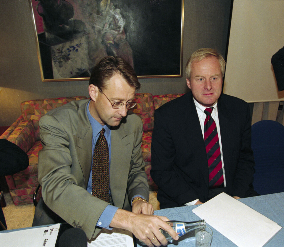 1. oktober 1996 overtok selskapet Resource Group International (RGI) med Kjell Inge Røkke og Bjørn Rune Gjelsten styringen av Aker, etter å ha kjøpt seg kraftig opp i selskapet. På bildet er avtroppende konsernsjef Tom Ruud (til høyre) sammen med påtroppende styreformann i Aker RGI AS, Bjørn Rune Gjelsten, under presentasjonen av fusjonen. (Foto: Scanpix, Lise Åserud)