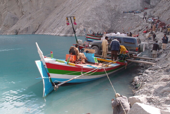 Karakoram Highway (Silkeveien) er ødelagt av ras, derfor må bil, utstyr og forskere fraktes med båt over Hunza-elven for å komme fram til forskningsfeltet.  (Foto: Richard Bischof)