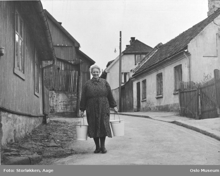 Vannbæring på Enerhaugen. Svært få av beboerne hadde innlagt vann. Ca. 1950. (Foto: Aage Storløkken) Vannbæring på Enerhaugen. Svært få av beboerne hadde innlagt vann. Ca. 1950. (Foto: Aage Storløkken)
