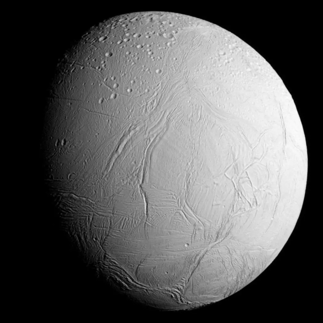 Ismånen Enceladus har fontener med vann som spruter opp fra overflaten. Forskere tror den har et indre hav med flytende vann. (Bilde: NASA/ JPL)