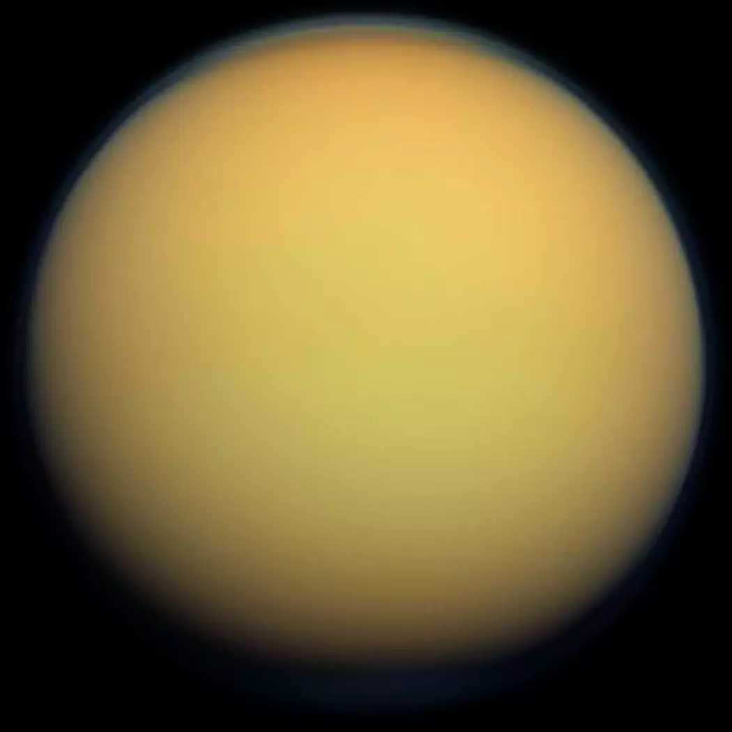 Titan er en spennende måne som ligner ganske mye på jorda. Den har atmosfære, landskap med fjell og sanddyner, vind og regn. Men regnet og innsjøene er av gassene metan og etan istedenfor vann. (Bilde: NASA)