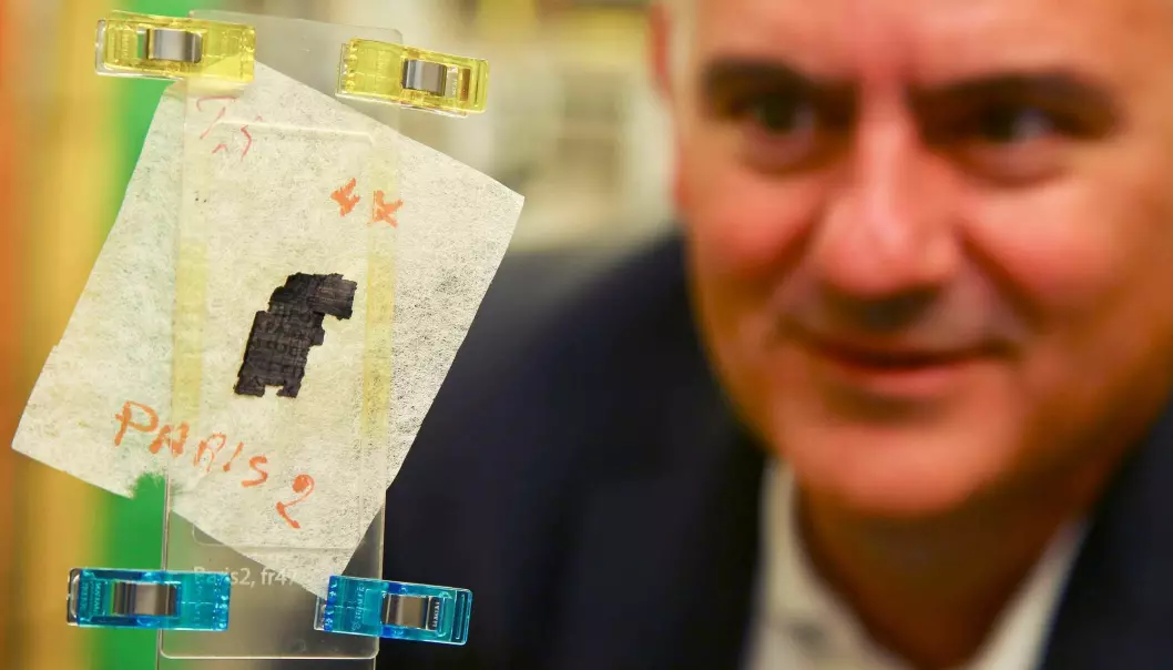 Her ser du forsker Brent Seales med en bit eldgammel papyrus som akkurat har blitt scannet. Nå håper forskerne at de skal klare å lese hva som står i ruller av papyrus som er funnet begravd i aske etter et vulkanutbrudd. (Foto: Geoff Caddick, AFP, NTB Scanpix)