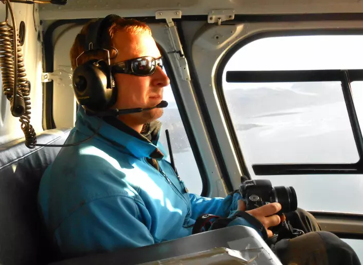 Christopher Nuth med kamera i helikopter over Kronebreen, klar for å gjøre opptak av nye kalvinger. (Foto: Universitetet i Oslo)