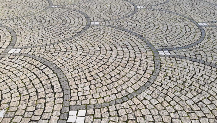 Brosteinsanlegg på Königsplatz med mønster av mørk basalt, lys granitt og hvit marmor. Brosteinsanlegg på Königsplatz med mønster av mørk basalt, lys granitt og hvit marmor.