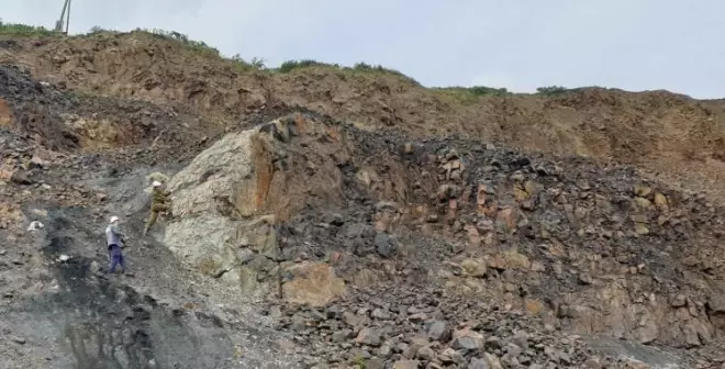 Geologists conducting field surveys in the Central Siberian Plateau. The photo shows a magmatic rock (intrusion) that has penetrated into sedimentary rocks that in the area have several layers of coal.
