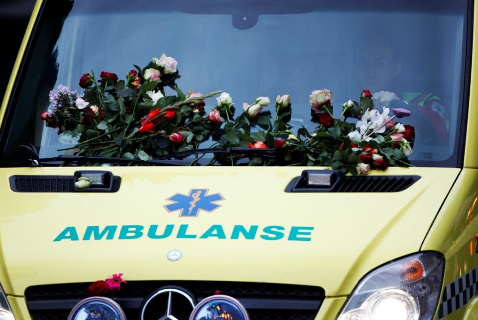 Ambulanse dekket med blomster. Over ett hundre tusen mennesker tok til gatene i Oslo for å vise støtte og omsorg for de omkomne etter bomben i regjeringskvartalet og i massakren på Utøya. (Foto: Trond Reidar Teigen / Scanpix)