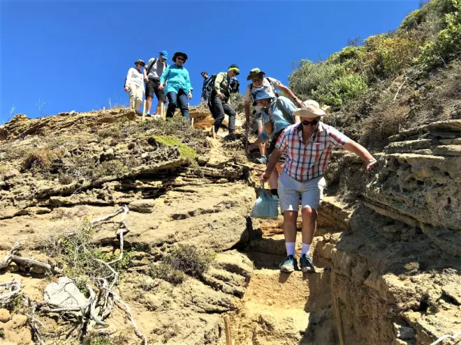 EXCURSION: The delegation climbs down the hillside to reach Blombos Cave.