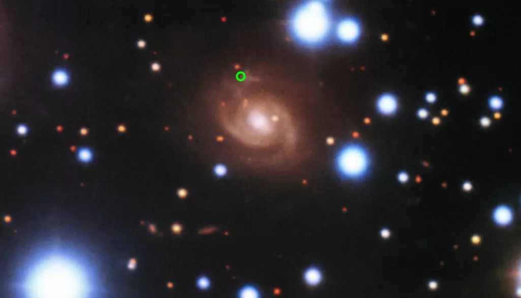 De gjentakende radioglimtene kom fra galaksen i midten. Den grønne sirkelen viser hvor.