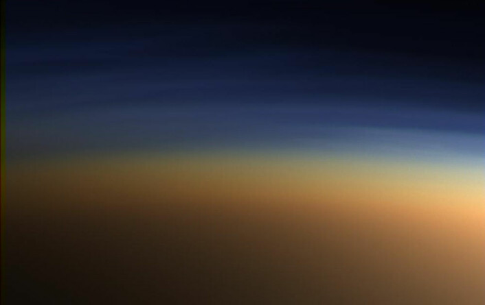 Dette bildet er tatt av Cassini da den passerte Titan i 2005. De øvre lagene av den tykke atmosfæren sprer blått og ultrafiolett lys, slik at tåken ser orange ut. (Foto: NASA)