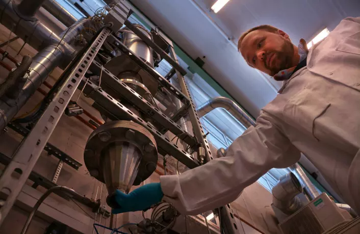 Forsker og områdeleder Werner Filtvedt henter ut silisumpulver fra Freespace-reaktoren som er utviklet ved Institutt for energiteknikk på Kjeller. (Foto: Arnfinn Christensen, forskning.no.)