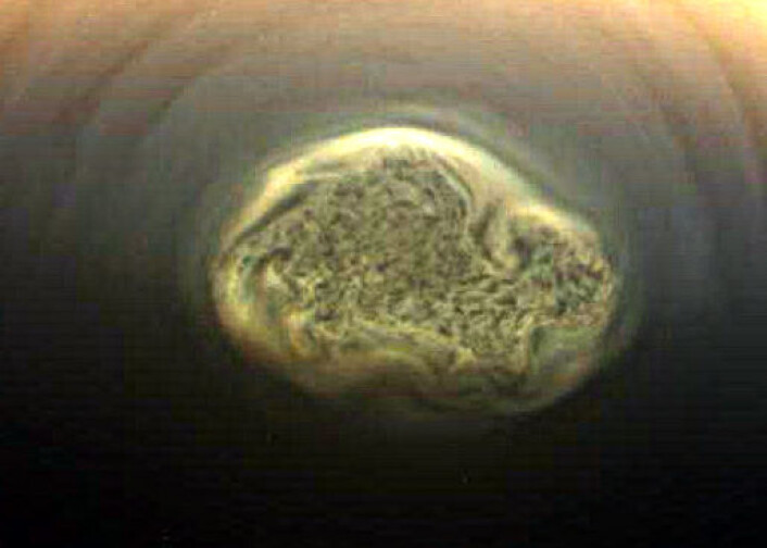Cassini tok dette bildet av orkanen som blåser rundt sydpolen på Titan. Forholdsvis varmere luft stiger i området rundt, avkjøles og suges ned i orkanens øye i midten. (Foto: NASA/JPL) Cassini tok dette bildet av orkanen som blåser rundt sydpolen på Titan. Forholdsvis varmere luft stiger i området rundt, avkjøles og suges ned i orkanens øye i midten. (Foto: NASA/JPL)