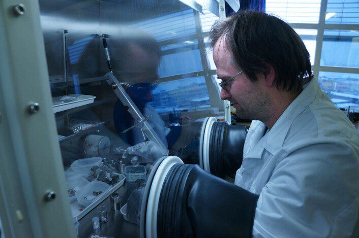 Seniorforsker Jan Petter Mæhlen arbeider med nanopulver av silisium i et skap fylt av edelgass, for å hindre uønskede kjemiske reaksjoner mellom silisium og luft. (Foto: Arnfinn Christensen, forskning.no.) Seniorforsker Jan Petter Mæhlen arbeider med nanopulver av silisium i et skap fylt av edelgass, for å hindre uønskede kjemiske reaksjoner mellom silisium og luft. (Foto: Arnfinn Christensen, forskning.no.)
