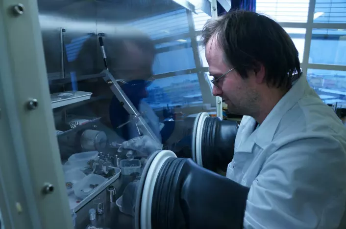 Seniorforsker Jan Petter Mæhlen arbeider med nanopulver av silisium i et skap fylt av edelgass, for å hindre uønskede kjemiske reaksjoner mellom silisium og luft. (Foto: Arnfinn Christensen, forskning.no.)