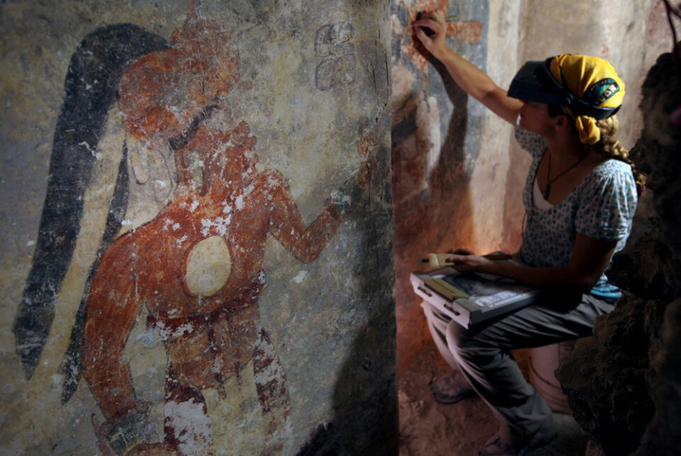Konservator Angelyn Bass renser go stabiliserer overflata av veggen i mayahuset. Figuren til venstre kan forestille mannen som holdt til i huset. Kanskje var han byens skriver? (Foto: Tyrone Turner/National Geographic)