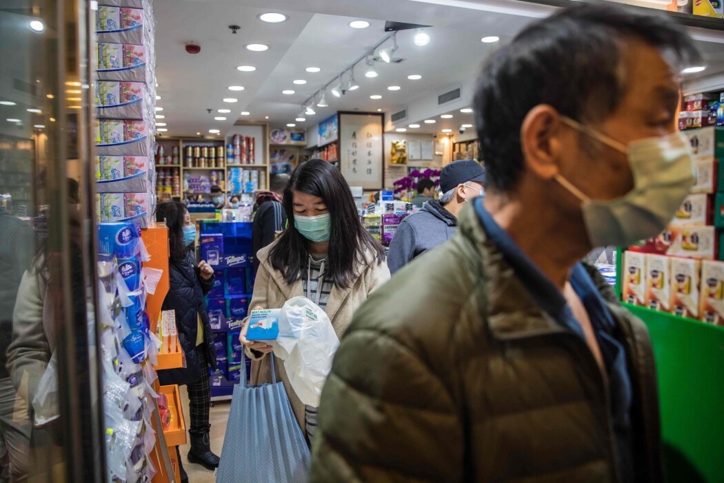 Bildet viser kunder på et apotek i Hongkong. Det rapporteres om lange køer med folk som skal kjøpe munnbind. Bildet viser kunder på et apotek i Hongkong. Det rapporteres om lange køer med folk som skal kjøpe munnbind.