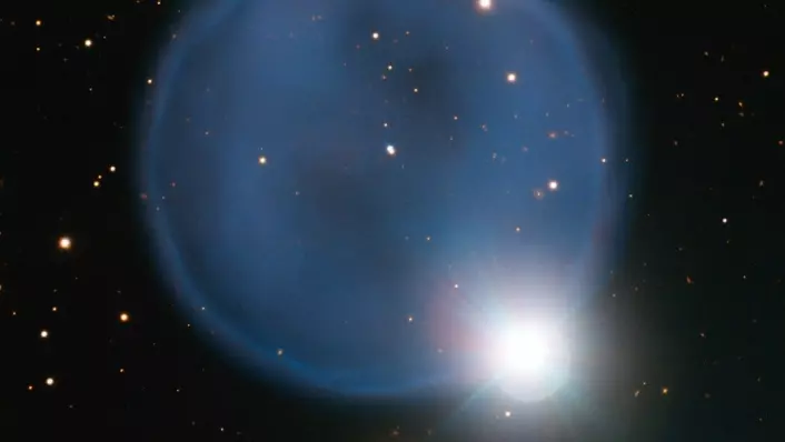 Stjerna som skapte den planetariske tåka kan skimtes som en lyssterk prikk i midten. (Foto: ESO)