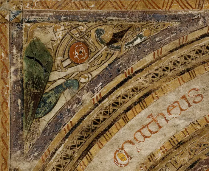 En helgenkriger med spyd og skjold blir bitt i armen av et dyr. Folio MS58_004r fra Kells-boken.