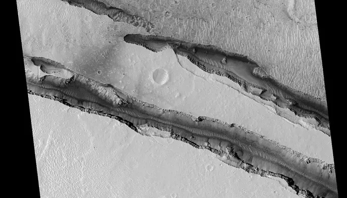 Disse sprekkene kalles Cerberus Fossae, og de er flere kilometer lange. De er avbildet av kameraet HiRISE på MRO-sattelitten
