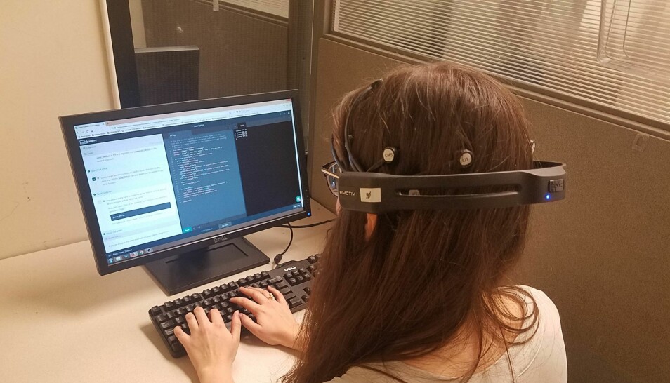 En av forskerne, Malayka Mottarella, viser koding mens et apparat måler hjerneaktiviteten hennes.